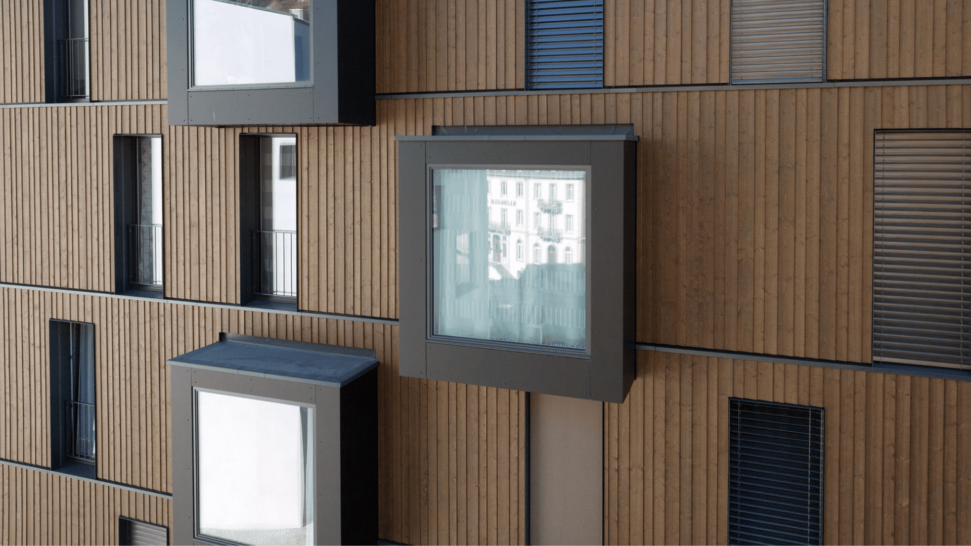 Braune Holz-Fassade und Fensterzargen als Stilelement