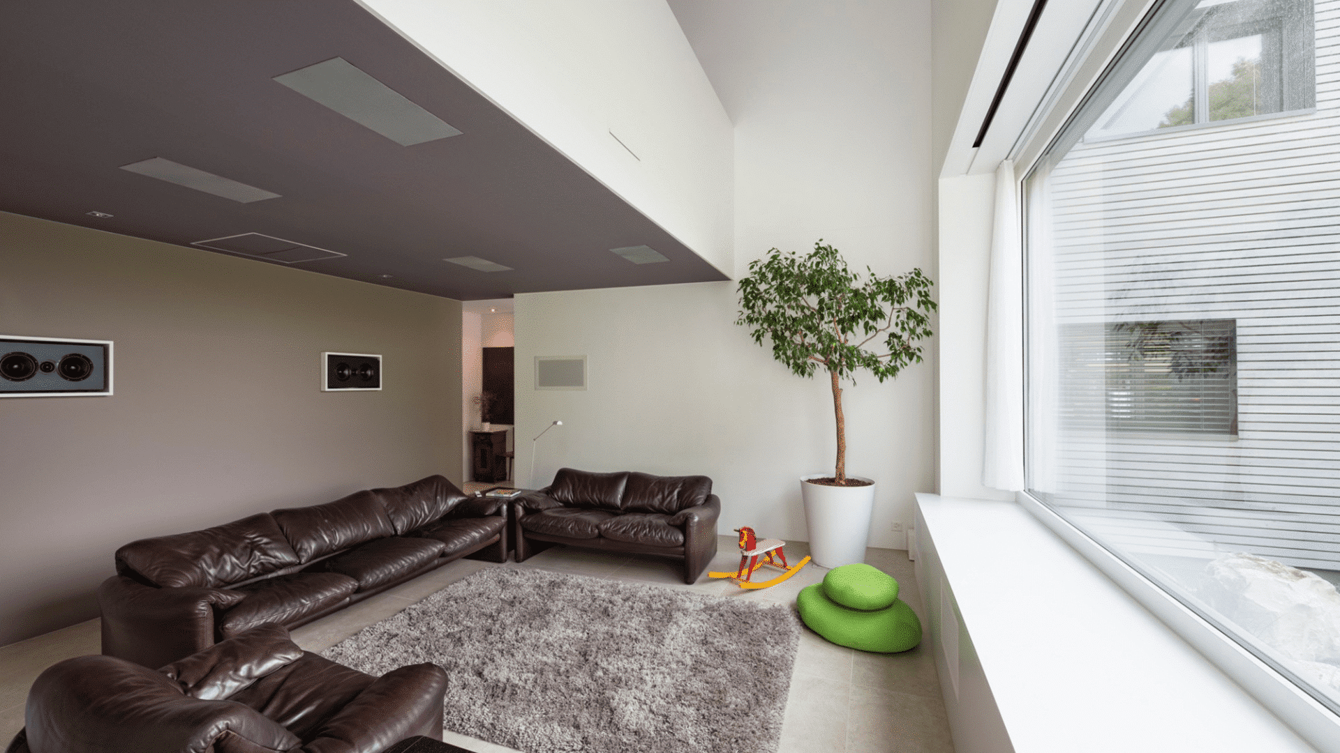 grosses Fenster mit Sitzbank und Wohnzimmer, braunem Sofa