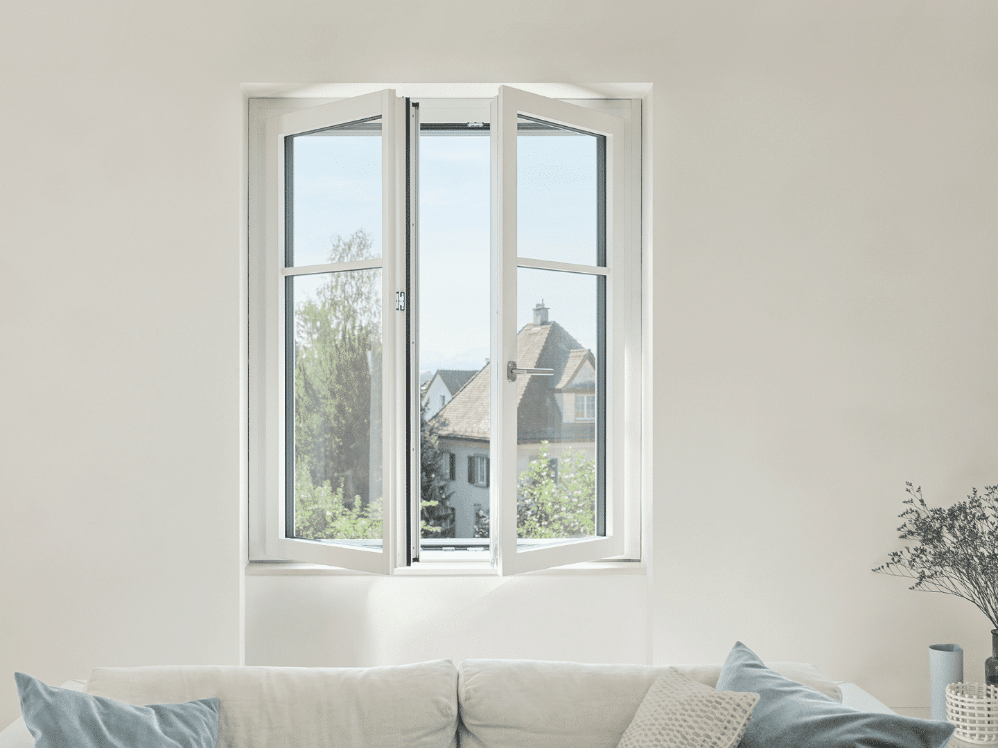 Weisses Renovationsfenster RF1 offene Flügel und weisses Sofa steht davor
