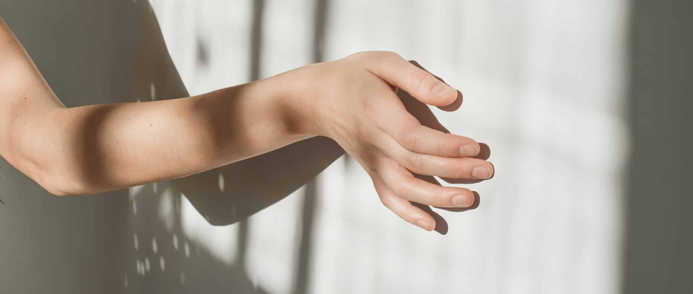 Der Schweizer Experte für Fenster und Fassaden: Hand mit Betonwand und Lichtspiel durchs Fenster