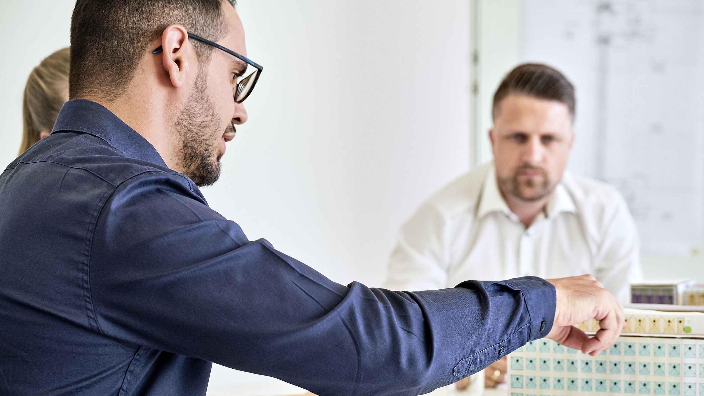 Im Meetingraum erklärt Mann an einem Prototypen