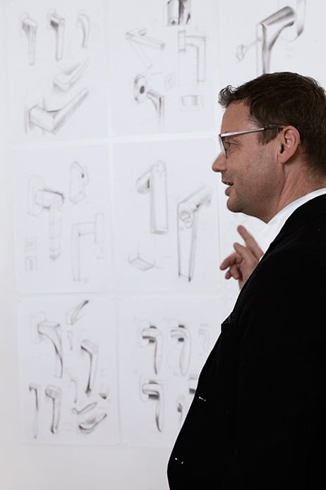 Le responsable de l'innovation, Bodo Gräbner, montre sur un mur des croquis avec de poignées de fenêtres.