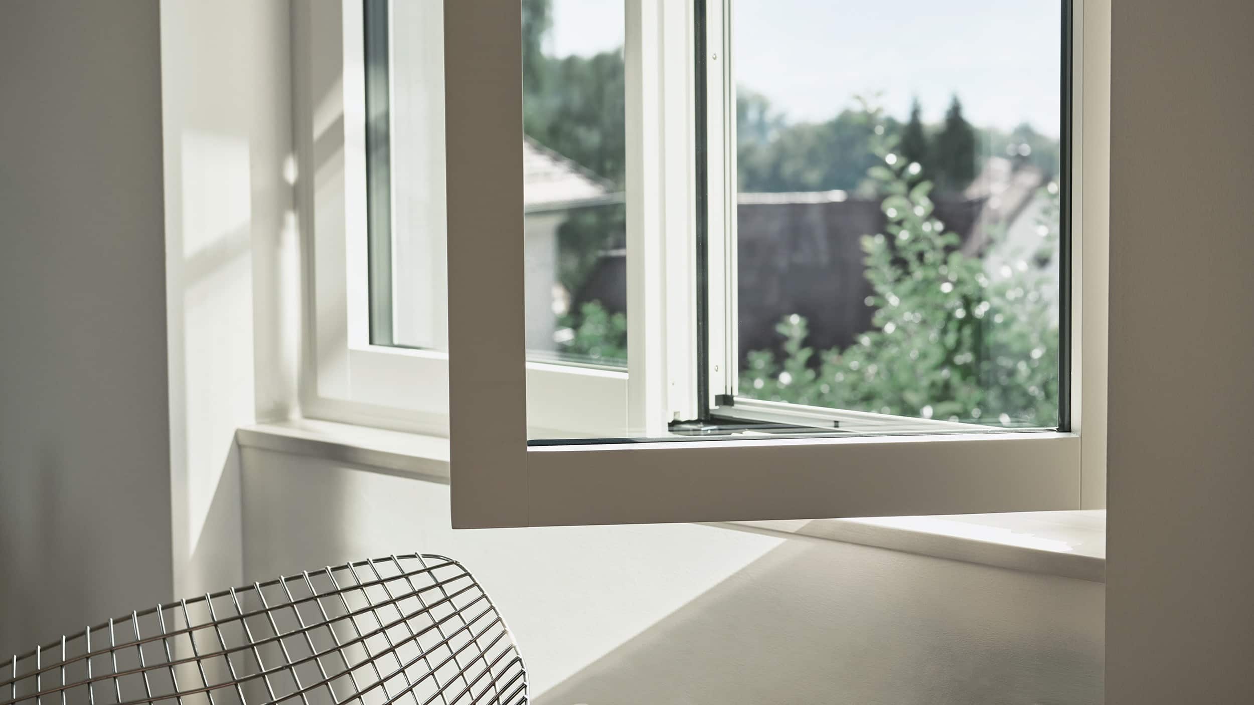 Renovationsfenster RF1 in weiss mit offenem Fensterflügel und Aussicht ins Grüne