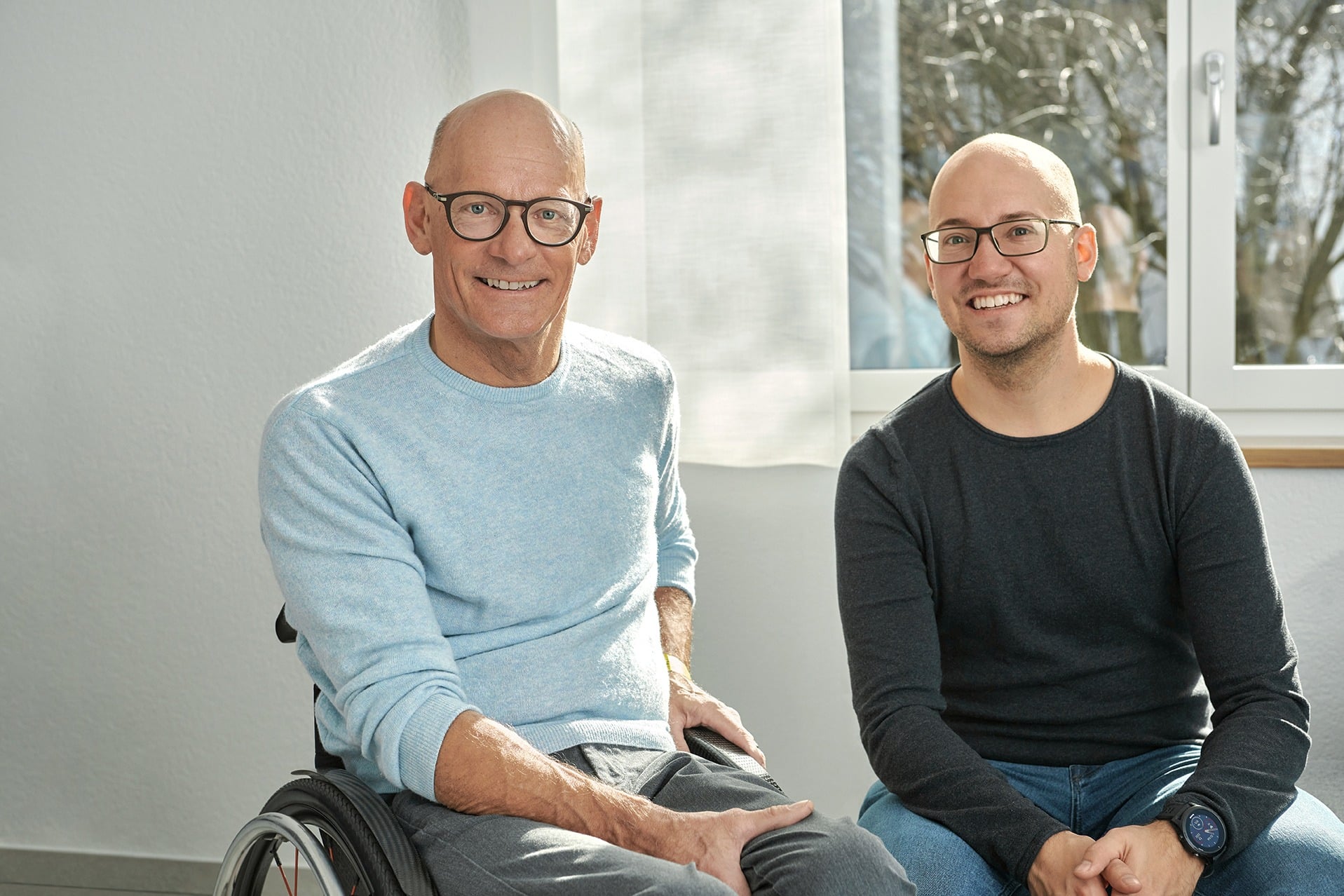 Heinz und Jan Frei sitzen vor einem neuen Renovationsfenster RF1