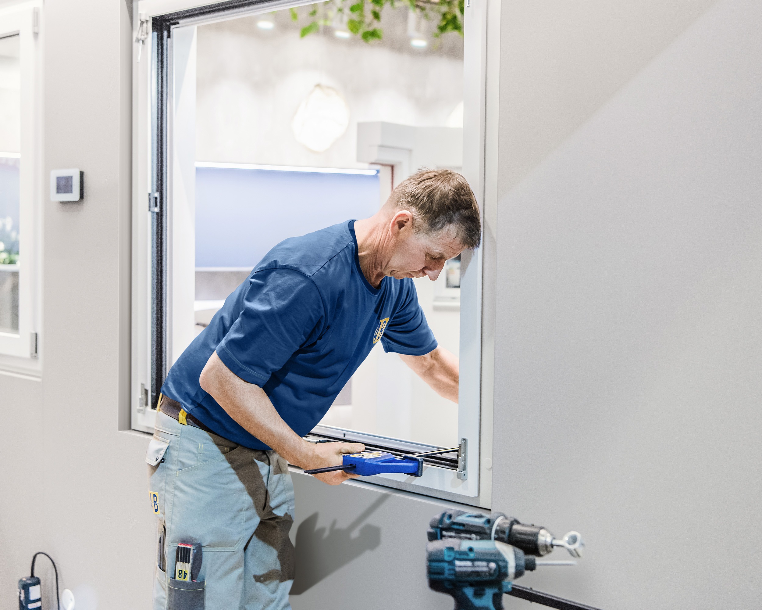 Monteur von 4B befestigt Fensterrahmen mit Schraubzwinge