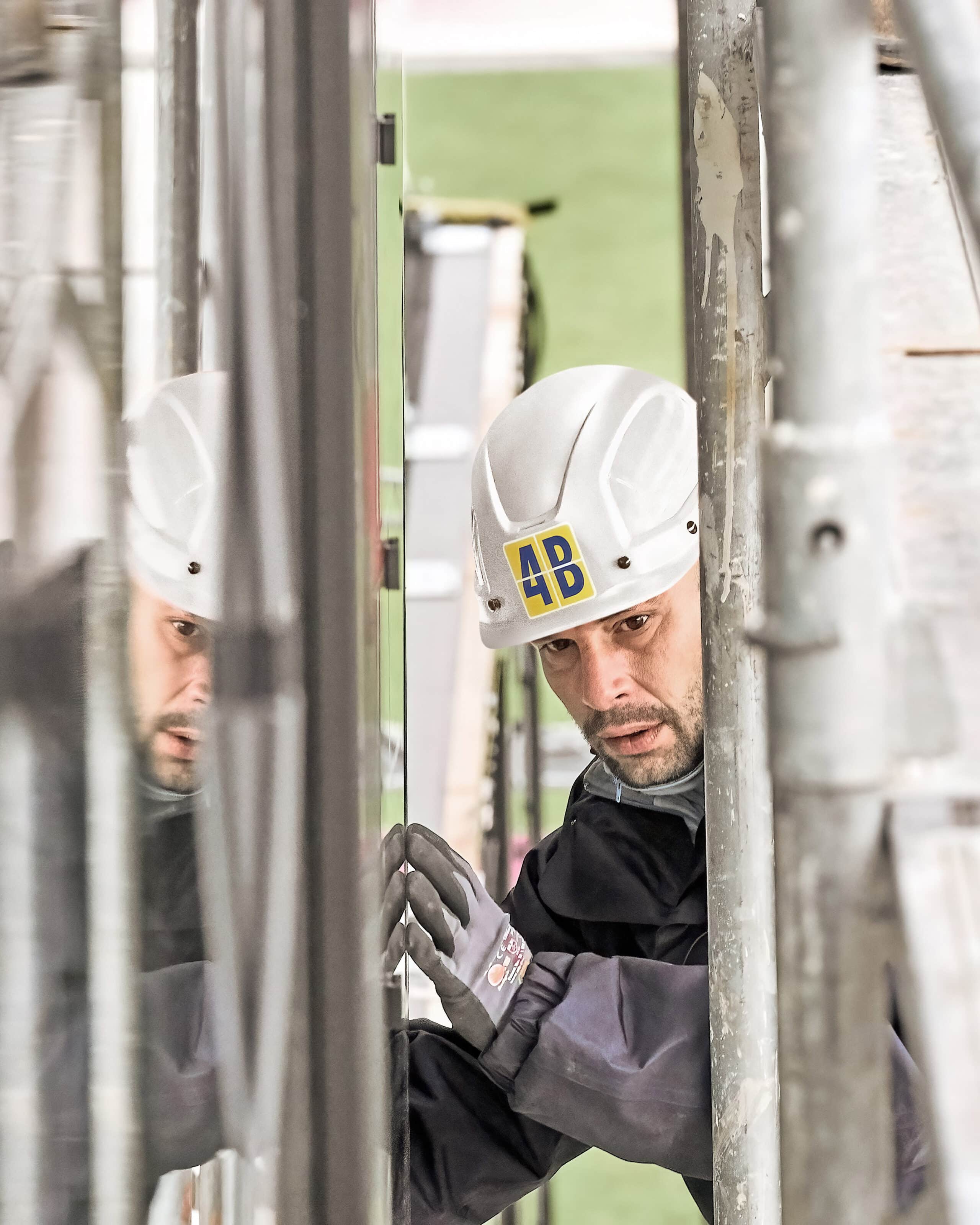 Un monteur de 4B inspecte un élément de façade sur le chantier