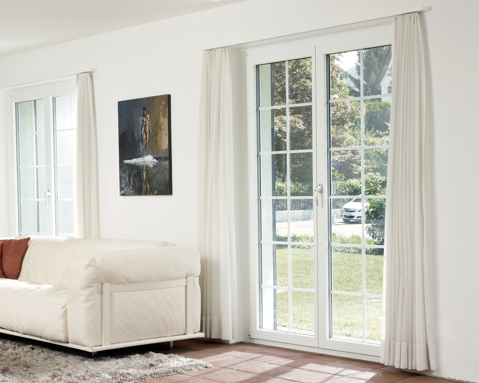 Wohnzimmer mit weissem Sofa und bodentiefen Fenster mit Landhaussprossen