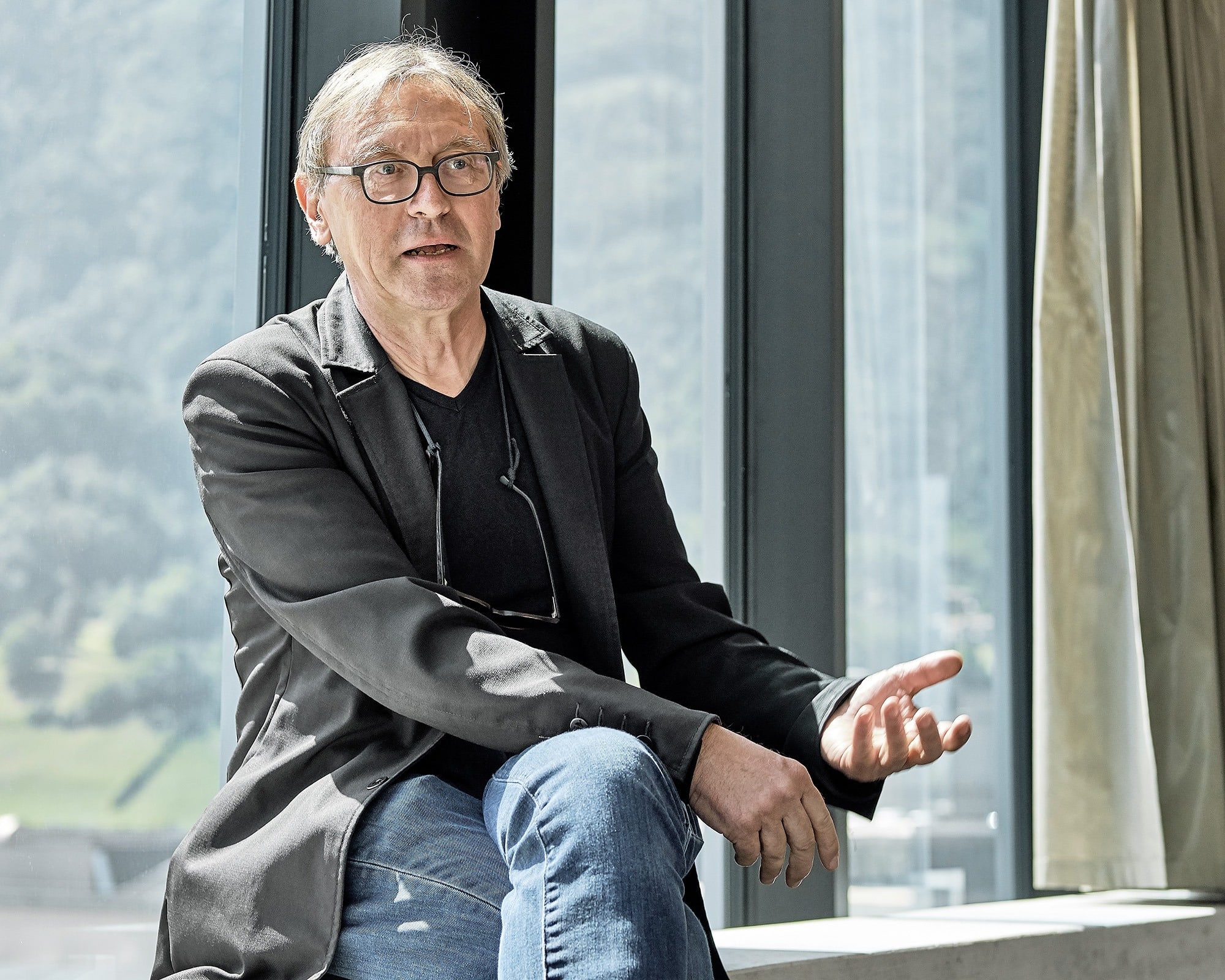 Der Architekt sitzt auf der Fensterbank und erzählt über das Projekt Siscampus