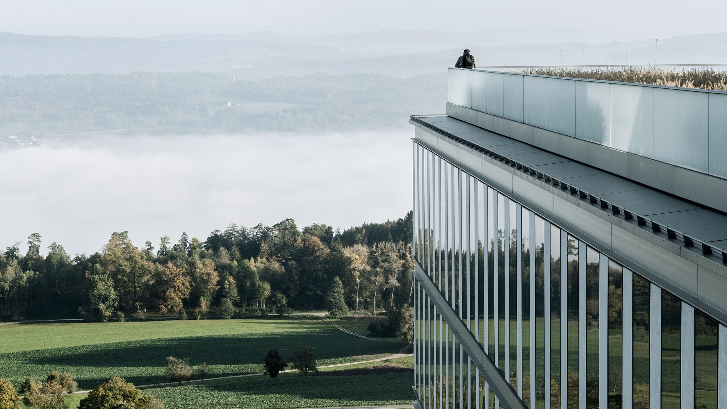 Mann steht auf der Terrasse der Rehaklinik Bellikon und betrachtet die Landschaft