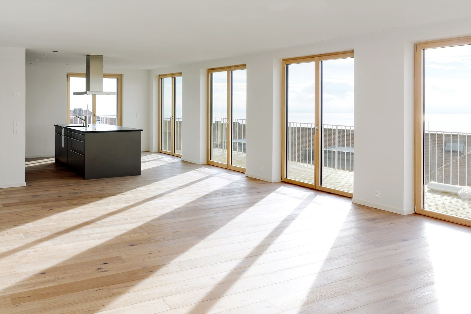 Helles Wohnzimmer und Küche mit grossflächigen Balkontüren und Fenster, Les Cadolles, Neuenburg