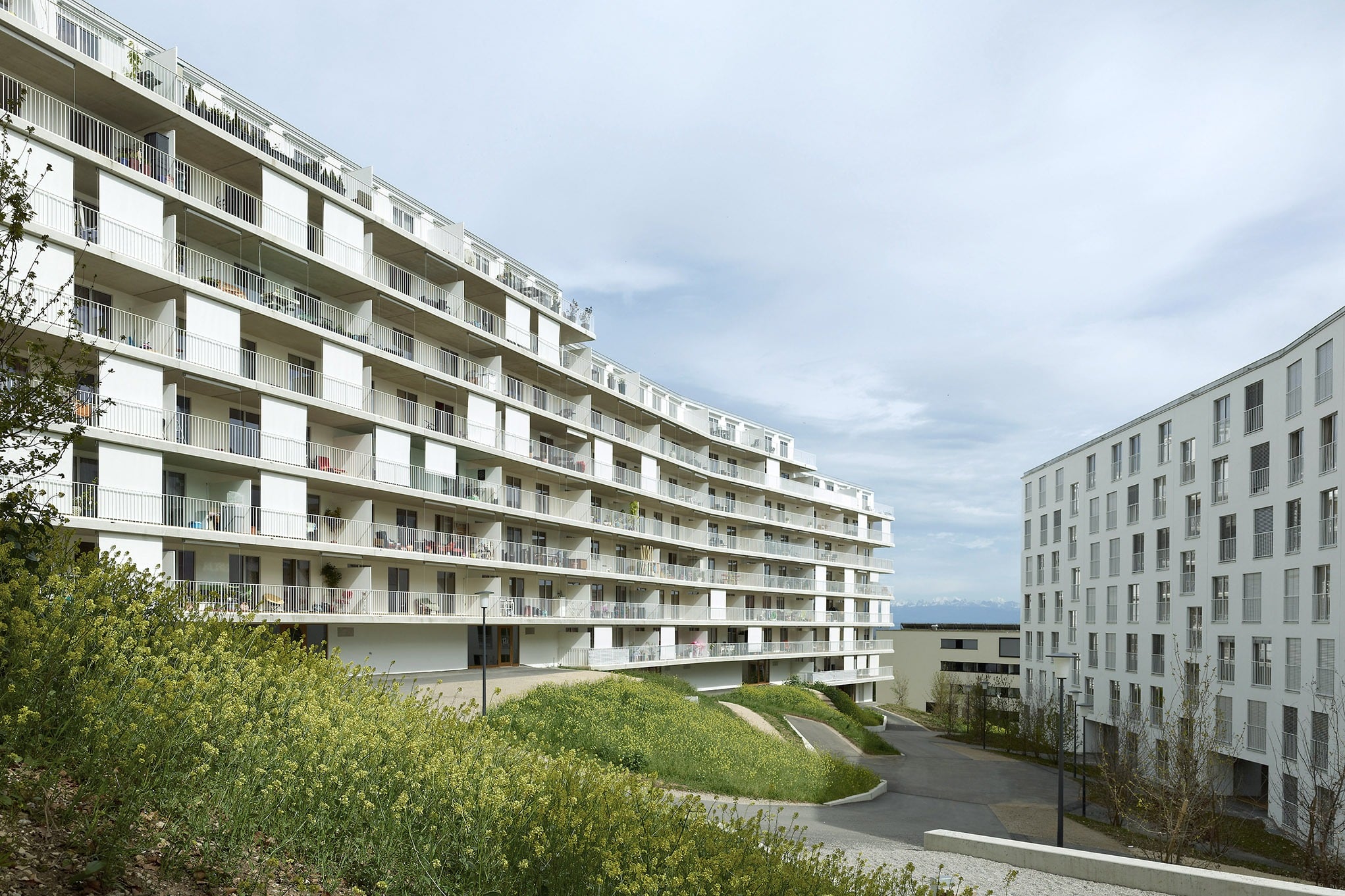 Aussenansicht an das Gebäude mit grossen Fenster und Balkontüren von 4B, Les Cadolles, Neuenburg
