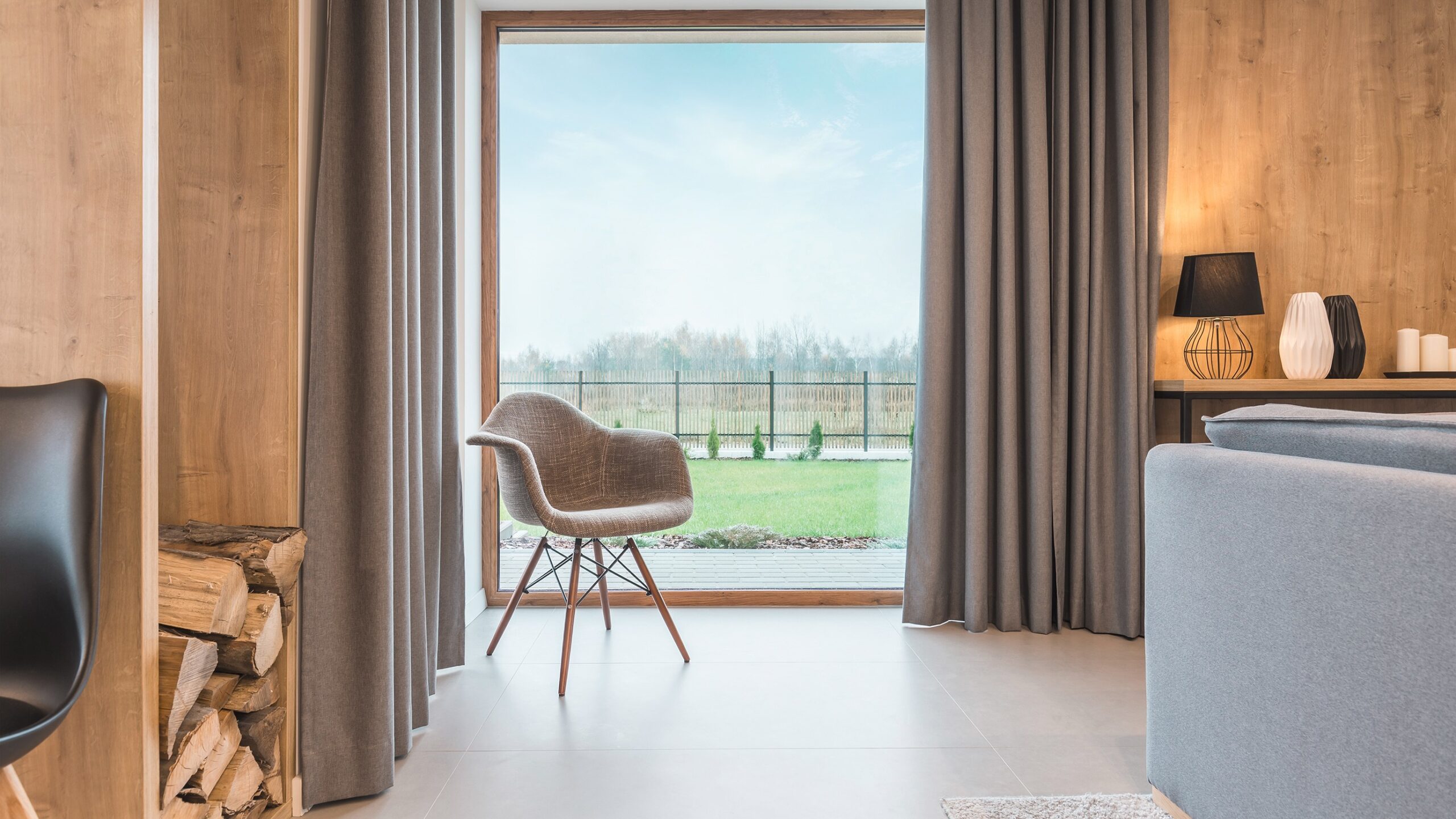 Grosses Fenster, heller Raum mit einem Sessel vor dem Fenster