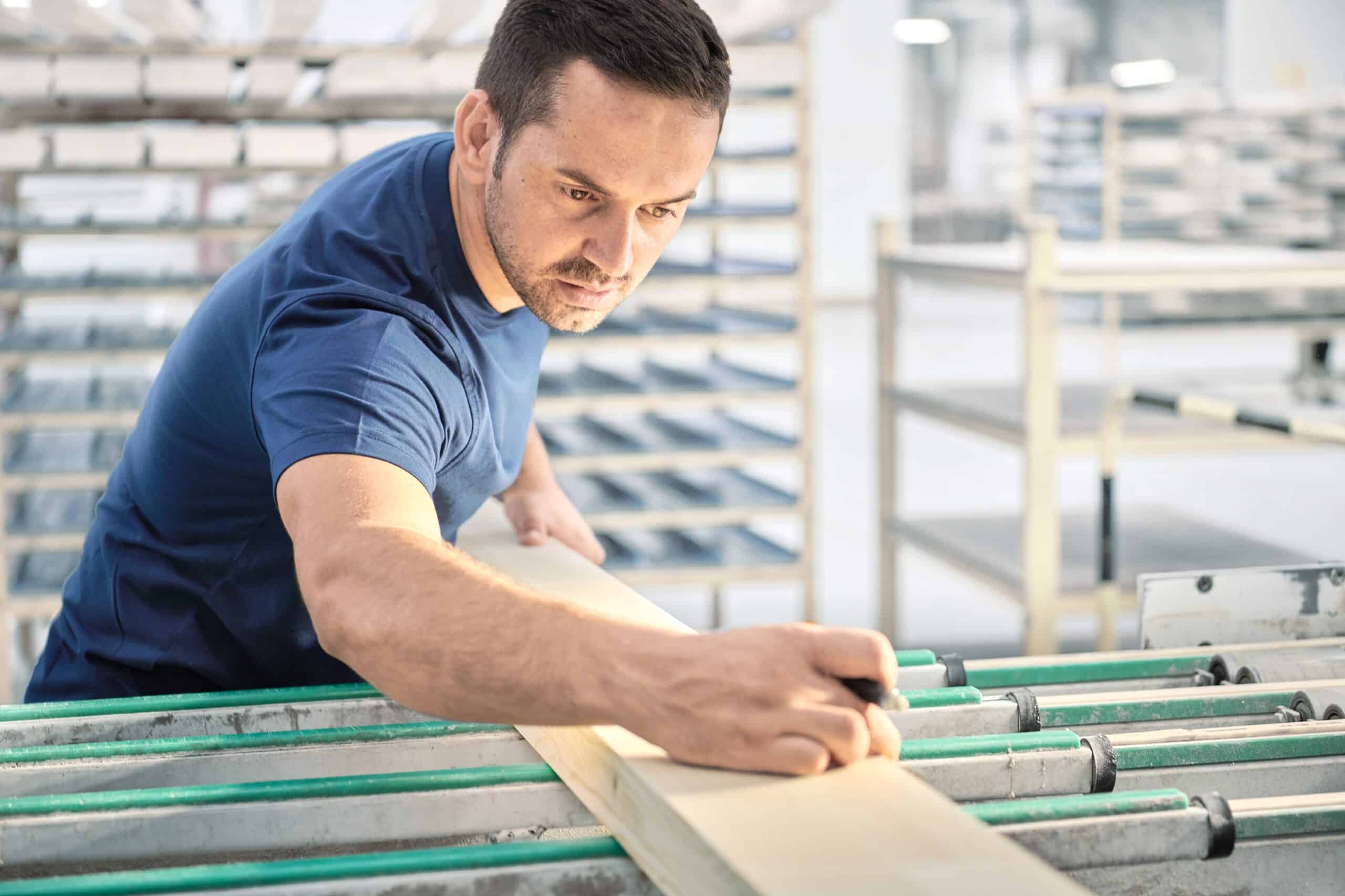 Der Schweizer Experte für Fenster und Fassaden: Ein 4B Mitarbeiter aus der Fensterproduktion kontrolliert die Holzqualität