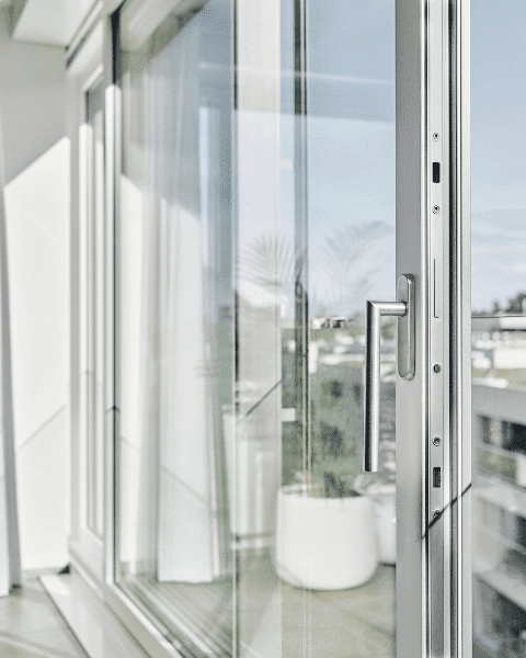 Grosse Fenster mit Aussicht und grüner Pflanze und weissen Vorhänge