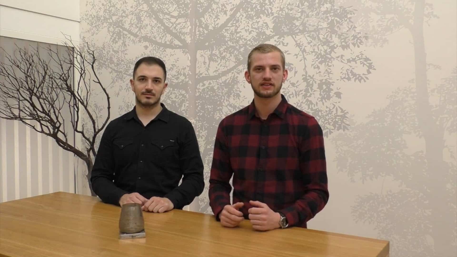 zwei Männer in einem Hemd stehen in einem Raum